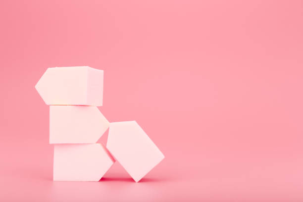 istock Stack of white make up sponges on pink background with copy space 1324759942