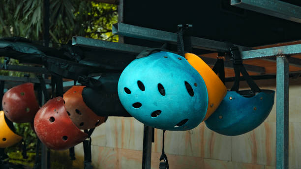 istock Colored protective helmets for the head to practice rafting hanging on the wall 1324760032