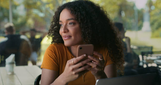 istock Shot of a young woman using her cellphone while sitting in a coffeeshop 1324760949
