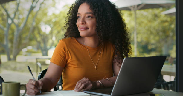 istock Shot of a woman making notes while using her laptop in a coffeeshop 1324761037