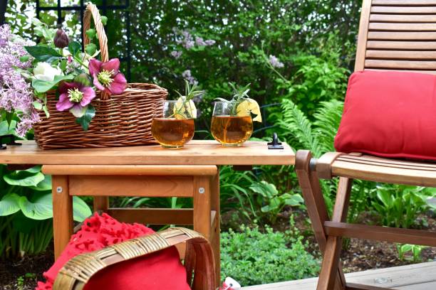 outdoor patio seating for relaxing in beautifully landscaped small space backyard on summer afternoon staycation - usa restaurant flower bed beauty in nature imagens e fotografias de stock