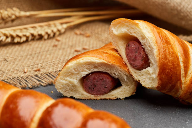 暗い背景にパフペストリーで焼いた生地でロールアップホットドッグソーセージ - blanket pig hot dog sausage ストックフォトと画像