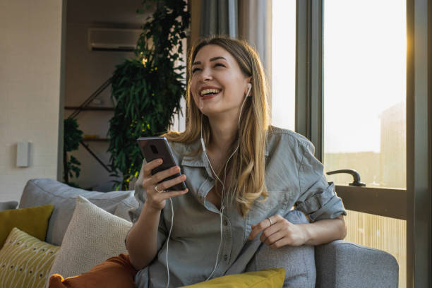 istock Young woman relaxing on the couch and using smart phone 1324767707