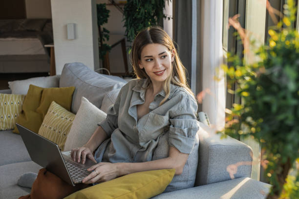 istock Young woman using laptop and relaxing on the couch 1324767744