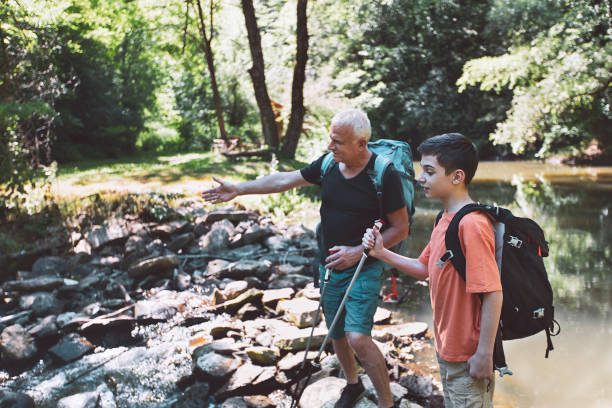 istock Happy grandfather and grandson crossing a river 1324767878