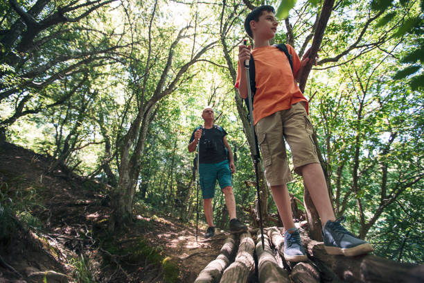istock Grandfather and grandson with backpacks walking in the forest 1324768043