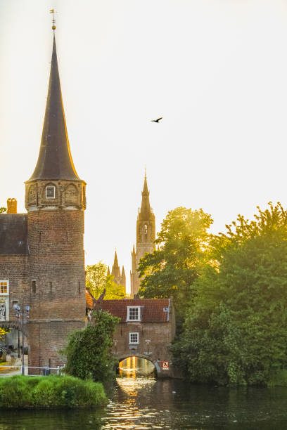 The three tower Sunset over canals in Delft featuring 3 towers (the Oostpoort- the Eastern gate- The New church and the Old Church. delft winter netherlands snow stock pictures, royalty-free photos & images