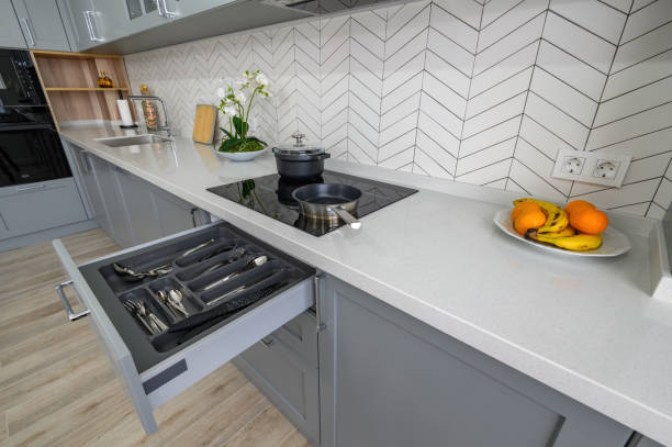 istock Trendy grey and white modern kitchen furniture with drawer pulled out 1324771474