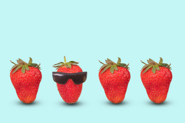 idée créative avec une fraise rouge exceptionnelle avec des lunettes et des fraises fraîches mûres sur fond bleu pastel. - gogles photos et images de collection