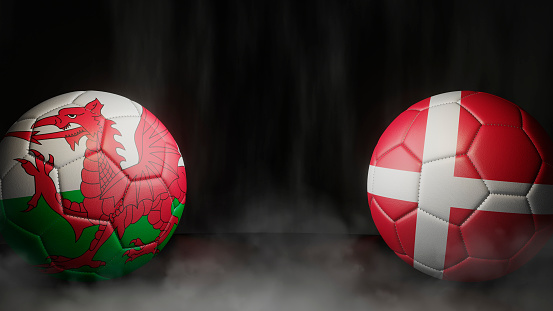 Two soccer balls in flags colors on a black abstract background. Wales and Denmark. 3d image