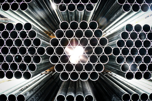 Construction tubes arranged in patterns in a warehouse. Industrial photography.