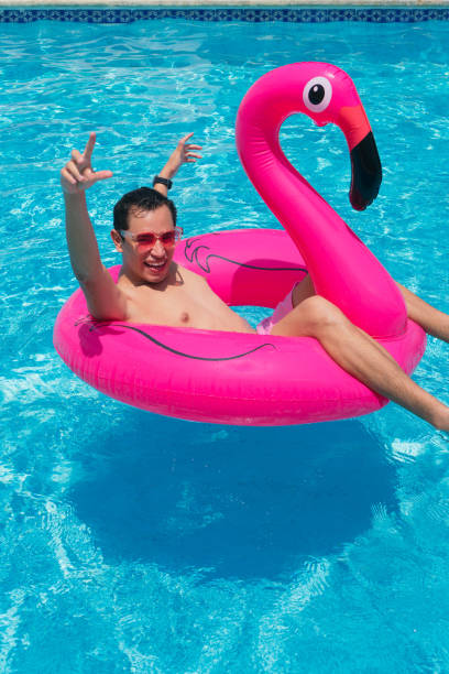 istock A man has fun on a fuchsia flamingo inflatable float in the pool. 1324776214