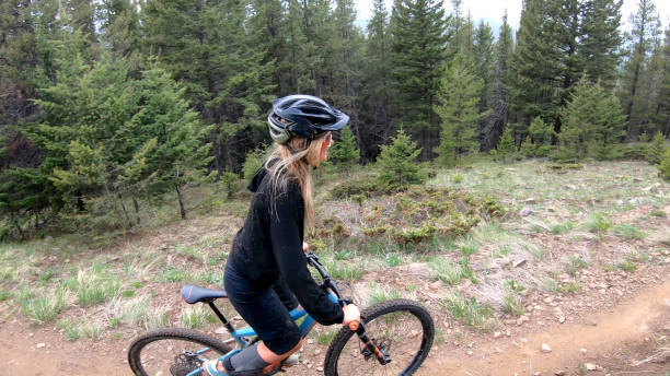 istock Female mountain biker follows forest trail 1324777867