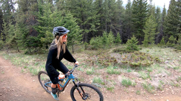 istock Female mountain biker follows forest trail 1324777879