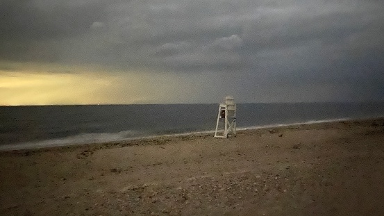 Lifeguard Chair on the Beach under an Overcast Dusk Sky