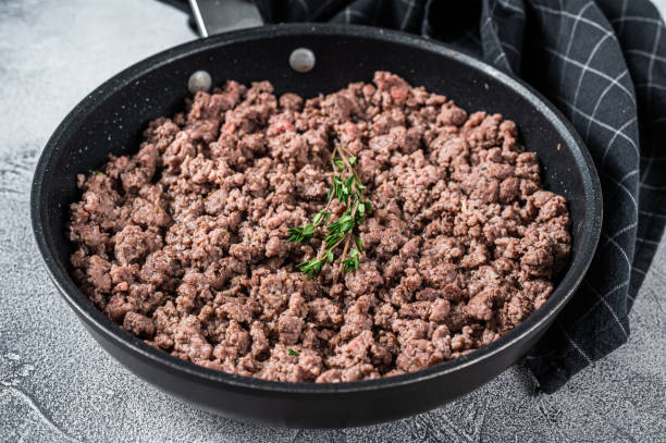 ハーブと鍋に牛肉と子羊肉を揚げます。白い背景。トップビュー - beef ground meat minced ストックフォトと画像