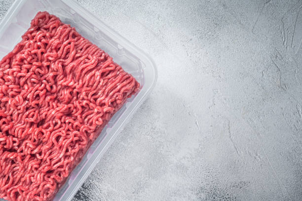 istock Fresh Raw mince beef and pork meat in vacuum packaging. White background. Top view. Copy space 1324782108
