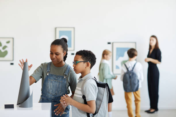 Kids in Modern Art Museum Minimal portrait of schoolchildren visiting art gallery and looking at modern sculptures, copy space museum stock pictures, royalty-free photos & images