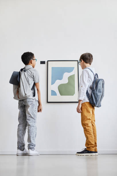 istock Two Boys Looking at Painting in Museum 1324782261