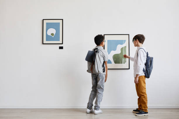 istock Two Boys Looking at Painting in Art Gallery 1324782265