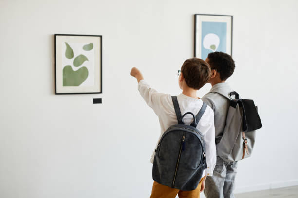 two boys looking at painting - museum child art museum art imagens e fotografias de stock