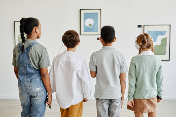 niños usando audioguía en la galería de arte - group of people art museum clothing lifestyles fotografías e imágenes de stock