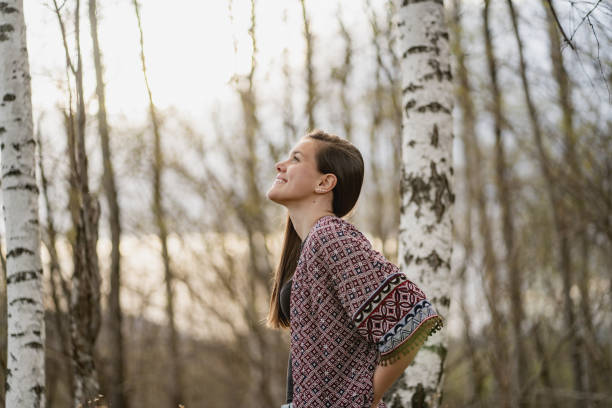 istock Beautiful Smiling Young Woman in Birch Forest 1324783785