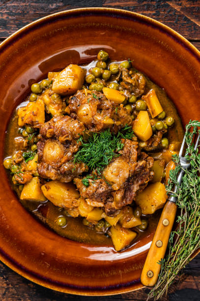 istock Beef veal oxtails stew with vegetables in a rustic plate. Dark wooden background. Top view 1324783843