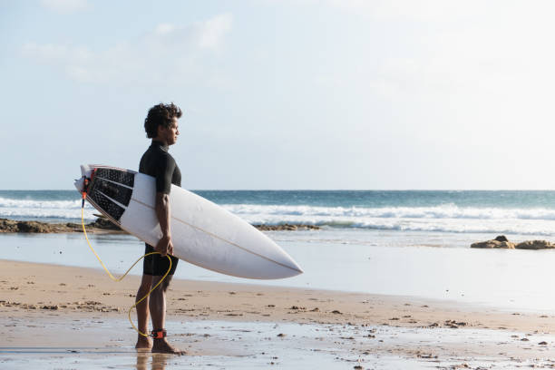 istock Young african malagasy surfer watching the waves standing at the beach shore 1324783938