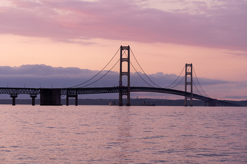Michigan's Mackinac Bridge in during the last light of the evening as the lights come on.  The bridge is an icon of Michigan and one of it's top tourist travel destinations.