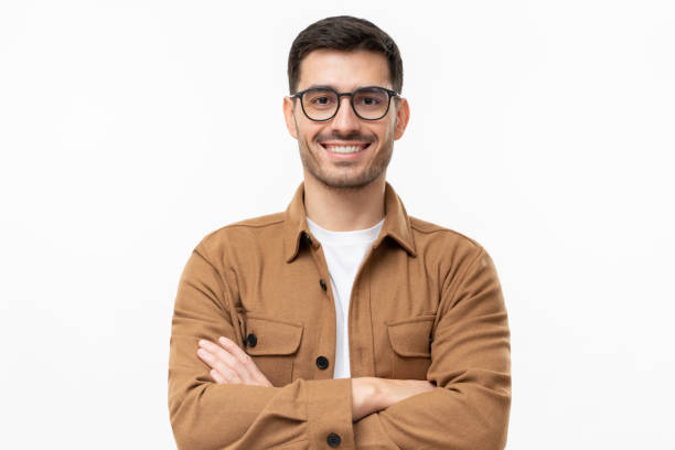 jeune homme beau souriant en chemise brune et lunettes, se sentant confiant, isolé sur fond gris - représentation masculine photos et images de collection