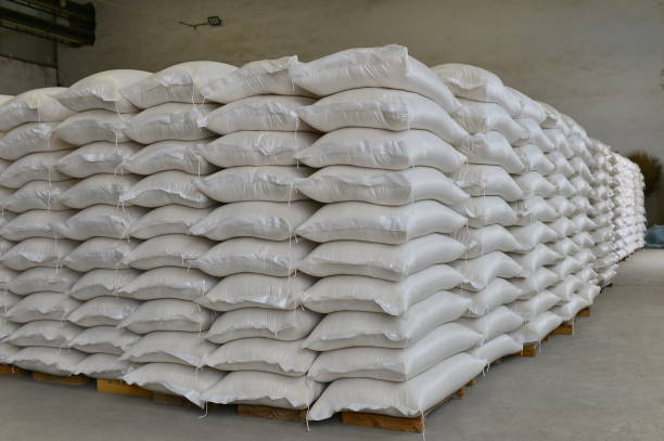 istock Many rows of plastic white sacks with goods are in big warehouse 1324792638