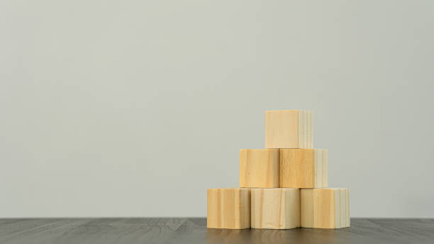 istock Wooden cubes or pyramid-shaped wooden blocks on the tabletop for white copy space and text entry. 1324792947