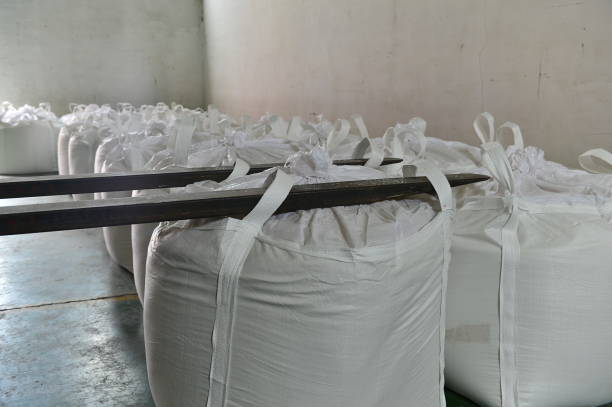 istock Many rows of plastic white sacks with goods are in big warehouse 1324793019