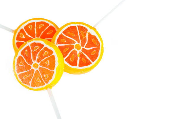 Orange flavored candy on a stick. Orange candies on a white background.