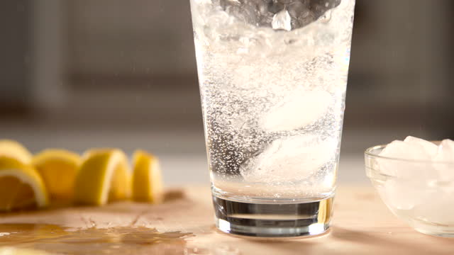 Close up of sparkling water with lemon and ice.