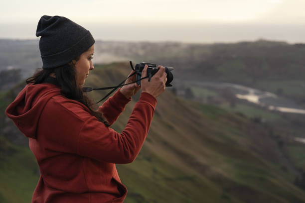istock Woman taking a photo with a camera in the mountains 1324800281
