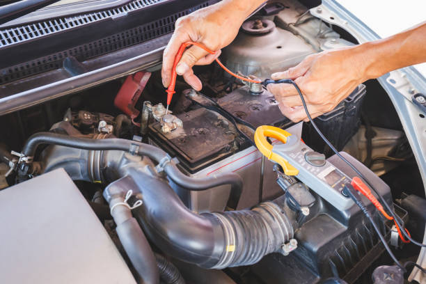 istock Auto mechanic working on car engine checking battery in mechanics garage, Repair and Maintenance service 1324801023