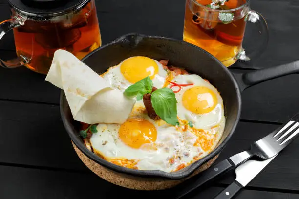 Top view of metal frying pan with three fried eggs