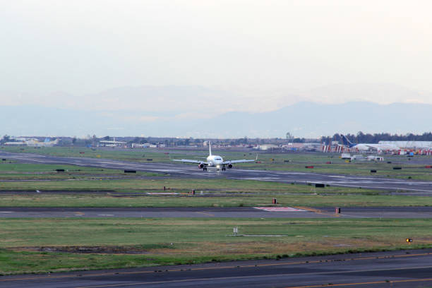 istock Commercial airplane parked, taking off or landing on runway under blue sky with big clouds 1324806071
