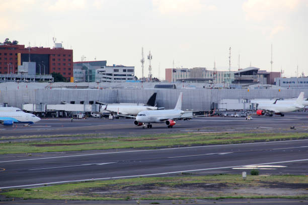 istock Commercial airplane parked, taking off or landing on runway under blue sky with big clouds 1324806074