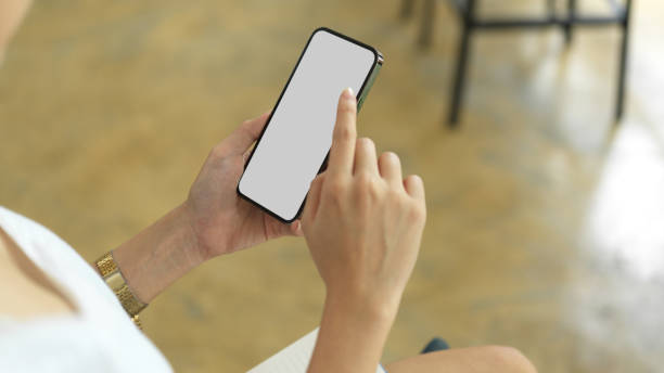 istock Close up view of female hands using smartphone with mock-up screen 1324806136