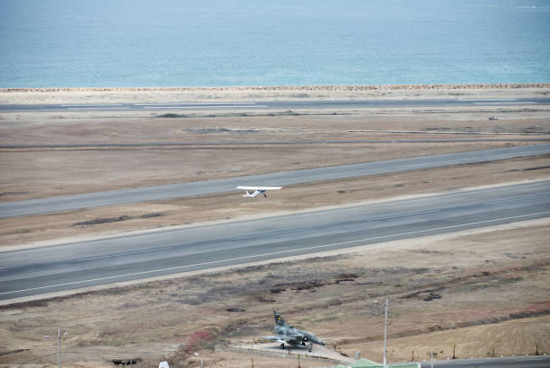 istock Light aircraft taking off on the runway next to the pacific ocean. 1324811342