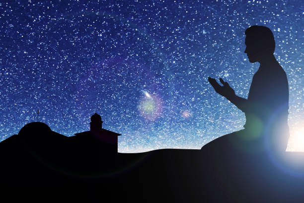 istock Silhouette of Muslim man sitting while raised hands and praying 1324811371
