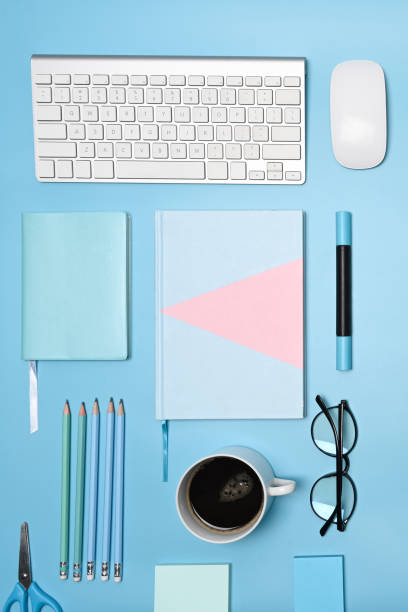 istock Notebook, coffee cup, keyboard, glasses and stationery on blue background. 1324812334
