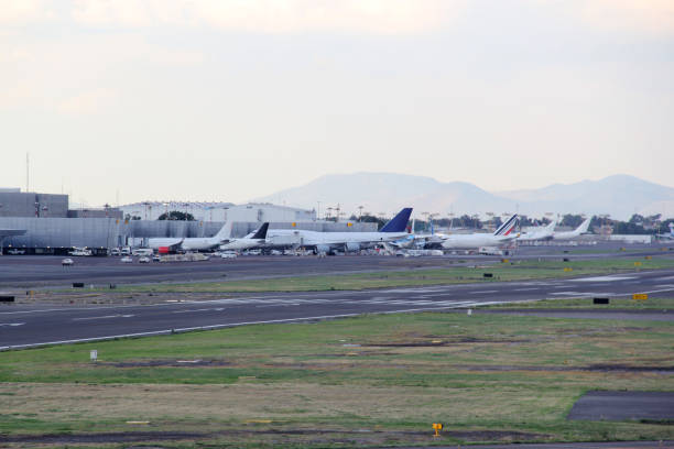 istock Commercial airplane parked, taking off or landing on runway under blue sky with big clouds 1324812549