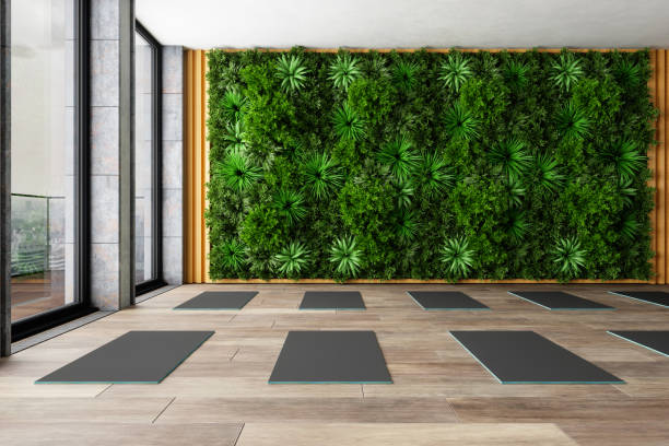 istock Empty Yoga Class With Exercise Mats On Parquet Floor And Walled Garden Background. 1324813307