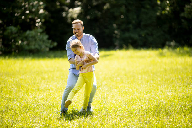 istock Father chasing his little daughter while playing in the park 1324814422