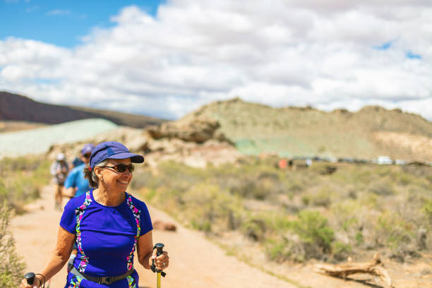 maturo adulto ispanico femmina e caucasico coppia maschile escursioni in arches national park utah photo series - hiking mature adult women senior adult foto e immagini stock