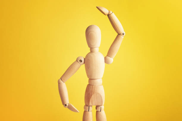 istock Wooden doll on yellow background 1324820168